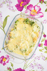 tasty casserole with broccoli on colorful napkin with pink flowers