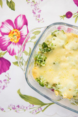 tasty casserole with broccoli on colorful napkin with pink flowers