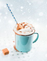 Christmas mood!) Hot chocolate with cream, cinnamon and a toffee in a blue vintage mug on a light background. The best celebration background. Winter xmas holidays concept.