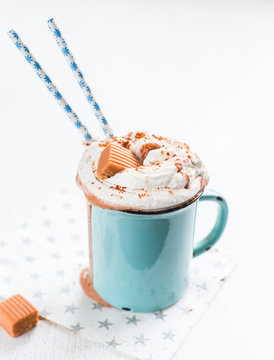 Christmas mood!) Hot chocolate with cream, cinnamon and a toffee in a blue vintage mug on a light background. The best celebration background. Winter xmas holidays concept.