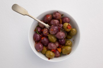 Olives and spices with spoon in bowl 