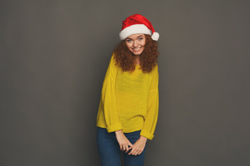 Fototapeta premium Young laughing attractive woman in santa hat