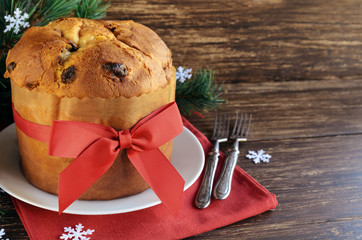 Traditional Panettone cake with dried fruits on the wooden table with  Christmas decoration....