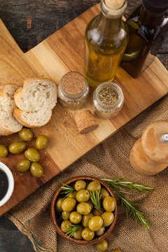 High angle view of olives and oils bottles with bread