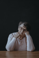 Grandmother in melancholy at table
