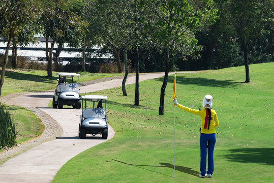 Golf - caddy holding flag, golfer reading green