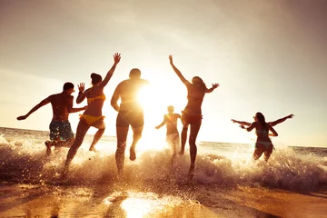 Fototapeten Big company of friends having fun at sunset beach © cppzone
