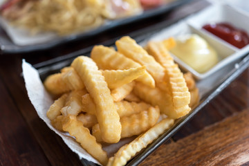 French fries in bowl on wooden background