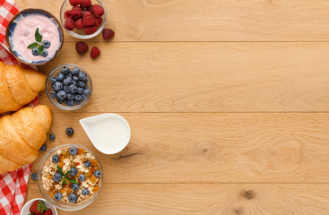 Continental breakfast with croissants and berries on natural wood
