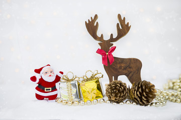 Christmas element concept, Santa clause with wooden reindeer and gift box over blurred light bokeh on white background