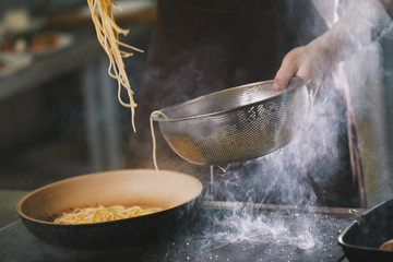 Cooking spaghetti in restaurant