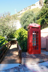 Typical English style vintage telephone booth located in Gibraltar Botanic Gardens