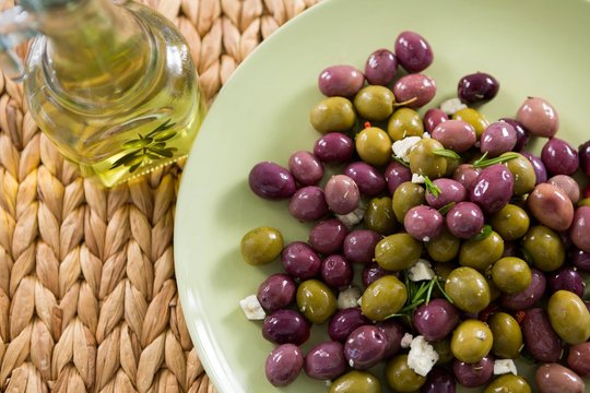 Marinated olives with olive oil on bamboo mat