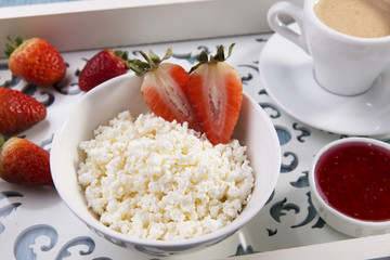 cottage cheese grainy crumbly with pieces of strawberries jam and coffee breakfast
