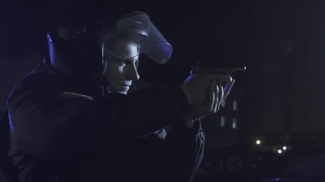 A police officer aiming a gun at the offender