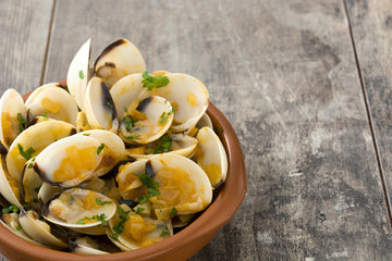 Clams with marinera sauce.Almejas a la marinera. Spanish recipe on wooden table