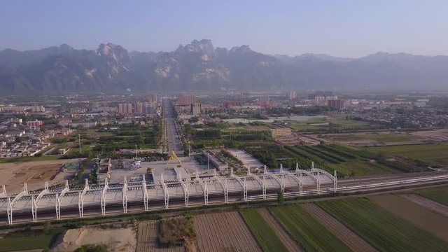 China Huayin Aerial v2 Flying low besides high speed train station with city mountain views 5/17