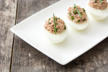 Stuffed eggs with tuna on wooden table