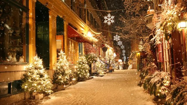 Looped footage of snow falling on deserted street decorated for Christmas.