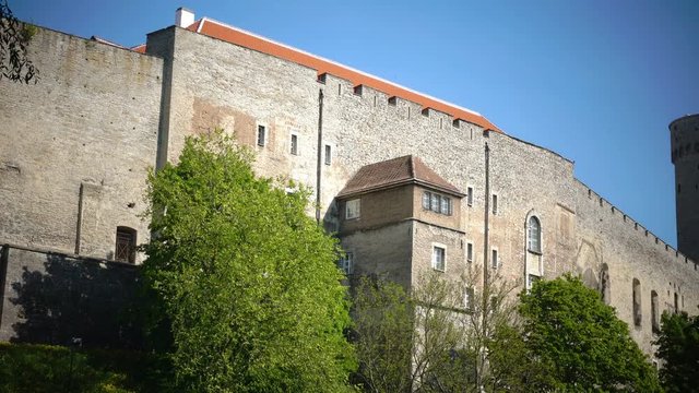 National flag of Estonia on blue sky move over Long Herman - a tower of Toompea Castle on the hill Toompea. Tallinn, Estonia