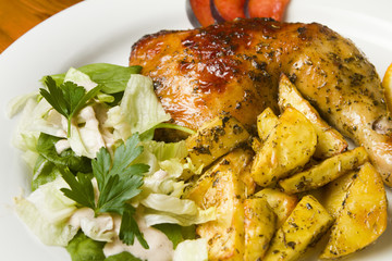 Chicken with potatoes  chips and salad on a white plate