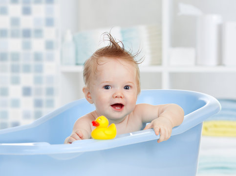 cute baby having bath in blue tub