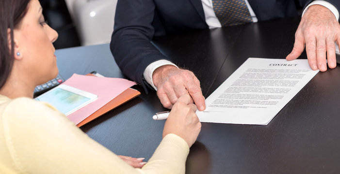 Woman signing contract with financial adviser
