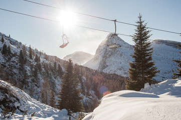 chair lifts with snow-capped dolomites in the background