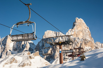 chair lifts with snow-capped dolomites in the background