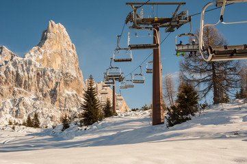 Fototapeta na wymiar chair lifts with snow-capped dolomites in the background