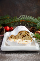 Christmas Stollen. Traditional German, European Festive Dessert on Old Wooden Table. Holiday Concept Decorated with Fir Branches and Cones. 