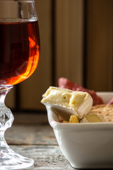 a piece of cheese and a glass of wine - a treat on the table
