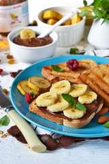 Good morning - toast with walnut, chocolate paste, banana and honey. White food background.