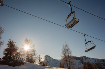 chair lifts with snow-capped dolomites in the background