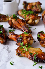 Chicken wings in orange sauce baked on a marble background