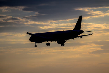 Airplane landing at sunset