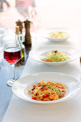 Table in a italian restaurant served with italian pasta.