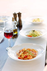Table in a italian restaurant served with italian pasta.