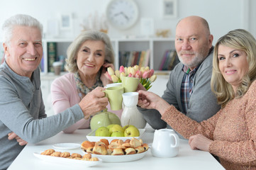 Obraz na płótnie Canvas two Senior couples drinking tea 