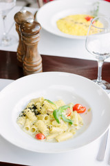 Rigatoni pasta with cheese and cherry tomatoes on italian restaurant.