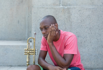 Unsuccessful african american artist with trumpet