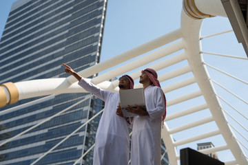 Two Arab businessmen convene to work together for a common goal and success city...