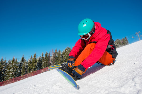 Shot of a snowboarder sitting on the snow preparing for riding the slope copyspace relax rest recreation winter sports activity hobby leisure concept