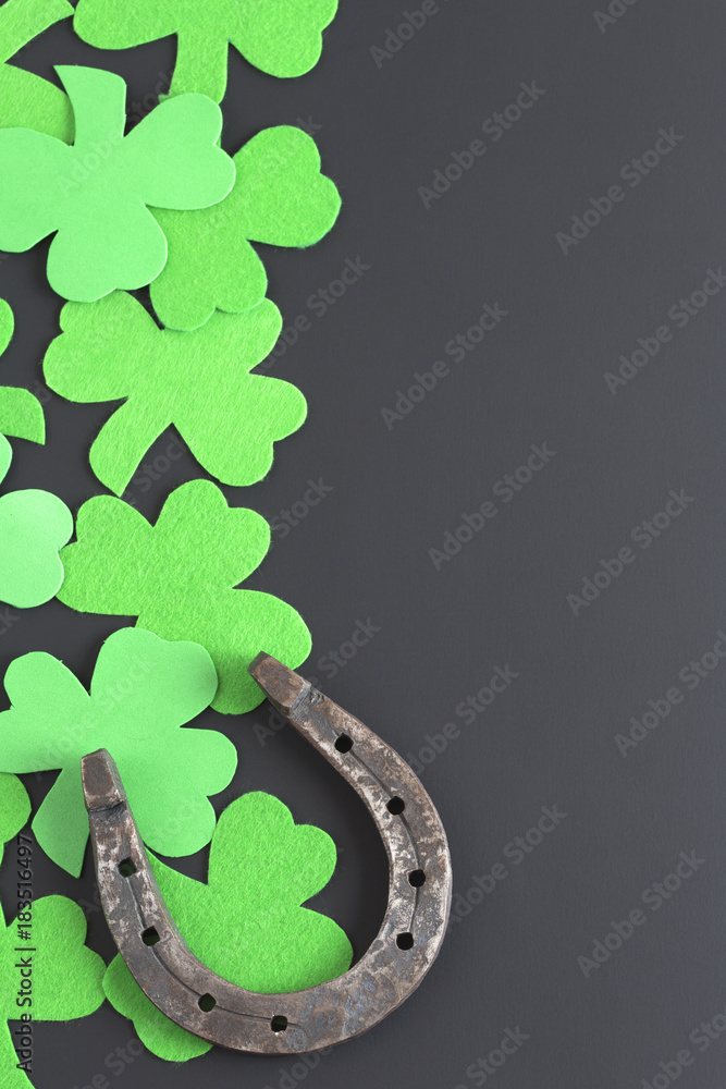 Wall mural clover and horseshoe on a dark background. st. patrick's day.