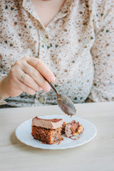 Woman eating small cake in a restaurant.