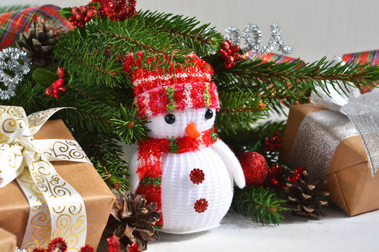 White New Year photo background with a snowman and decoration from boxes, balls. Happy New Year and Merry Christmas!