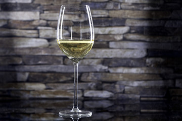 glass of white wine on stone
