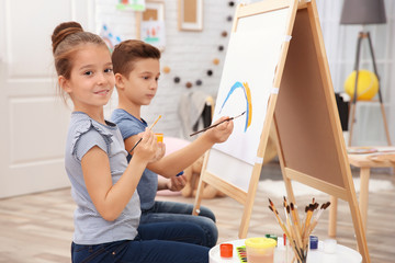 Little girl with brother painting at home
