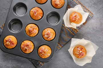 Tasty bacon muffins in mold on table