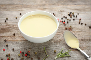 Ceramic bowl with ranch salad dressing on wooden background